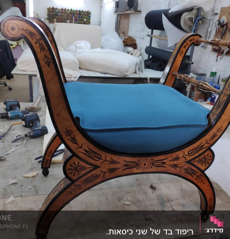 כיסא עם ריפוד כחול וסדנת ריפוד ברקע